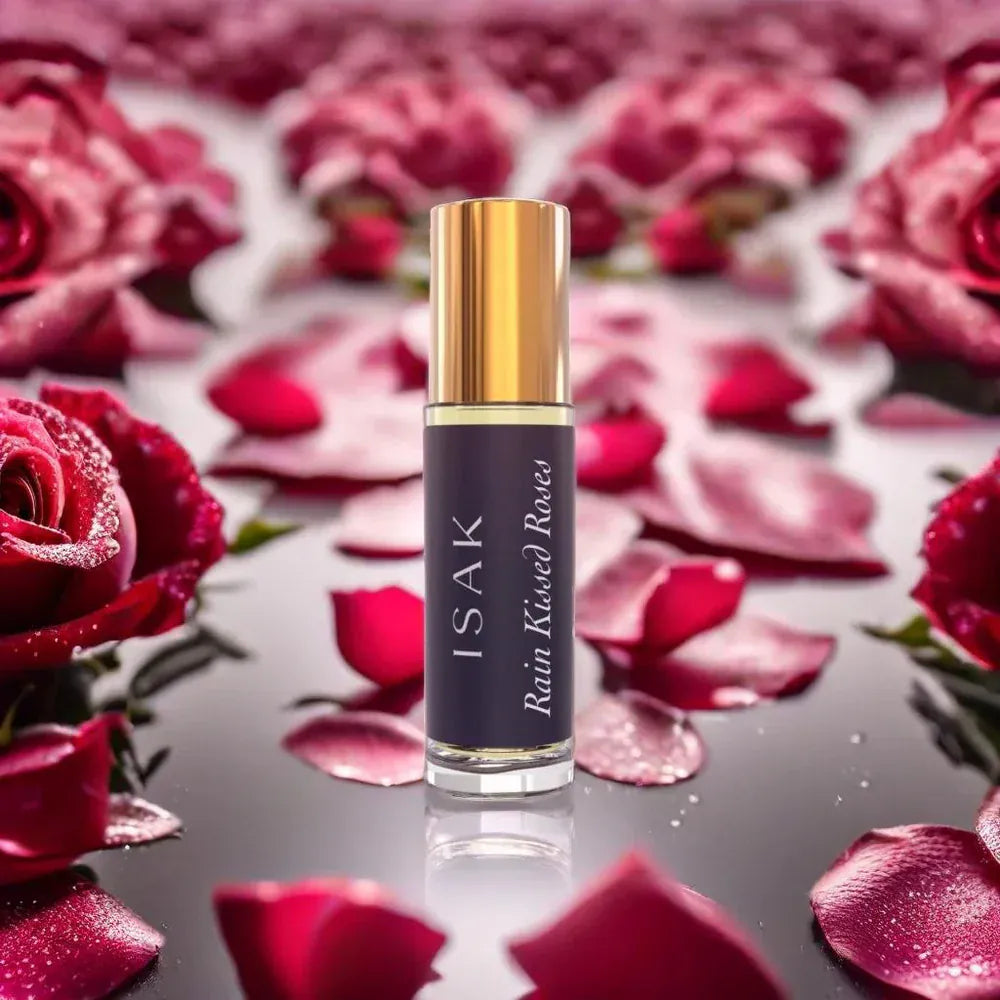 Mini attar bottle with gold cap and dark label among rose petals