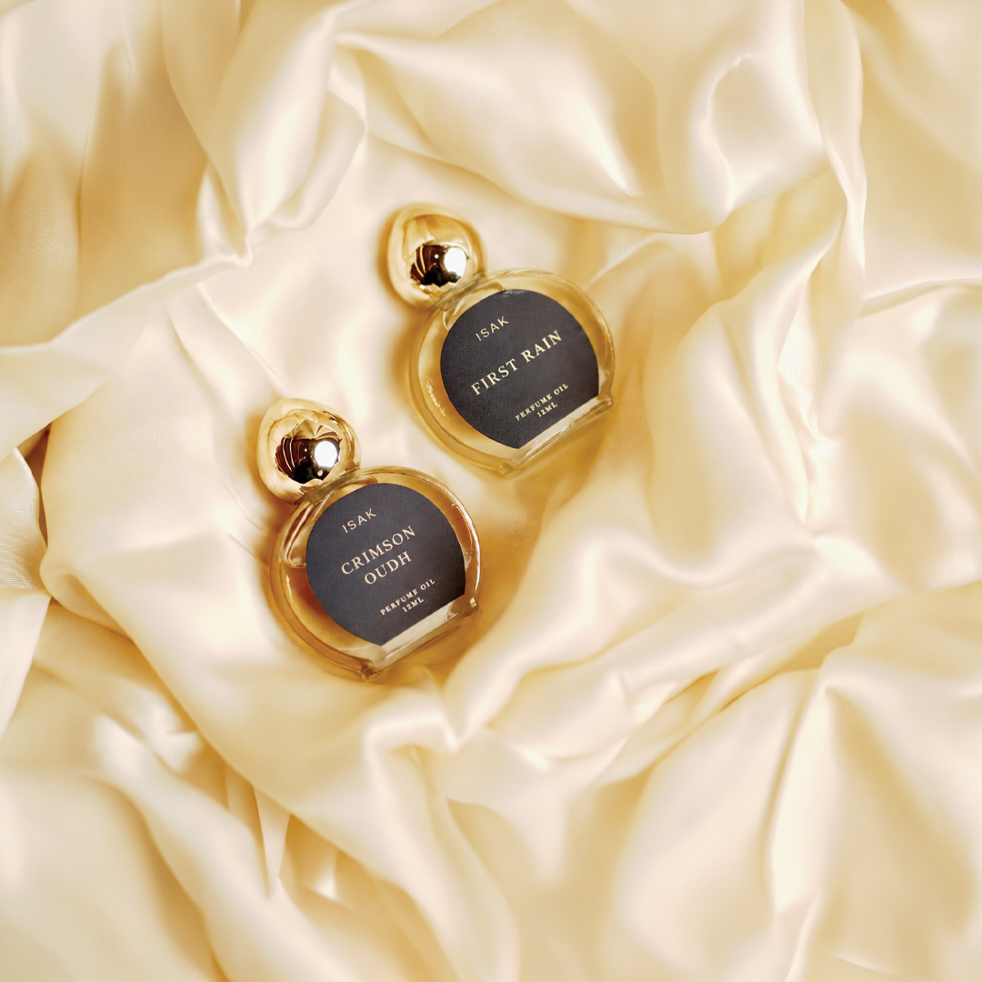 Gold heart-shaped attar bottles in cream gift pack, labeled First Rain and Crimson Oudh