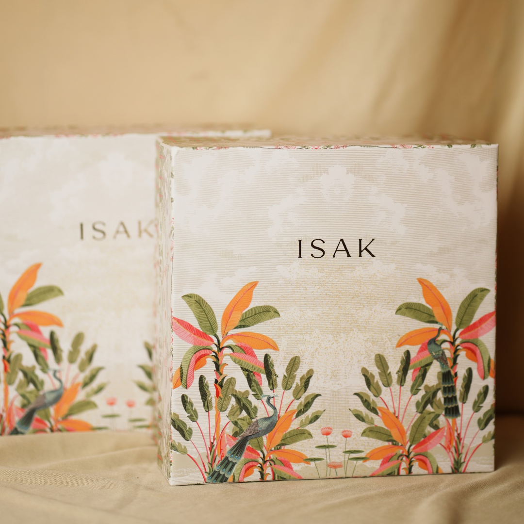 Gift box with ISAK label and orange-green botanical pattern on front