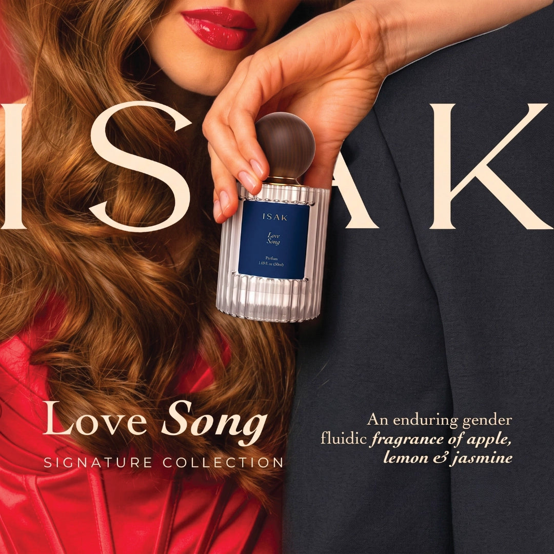 ISAK perfume bottle in hand, dark round cap, silver ribbed bottle with label.